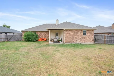 a swimming pool with yard and wooden fence