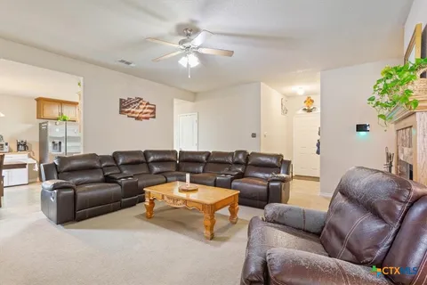 a living room with furniture a fireplace and a window