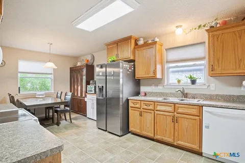 a kitchen with granite countertop cabinets sink and window