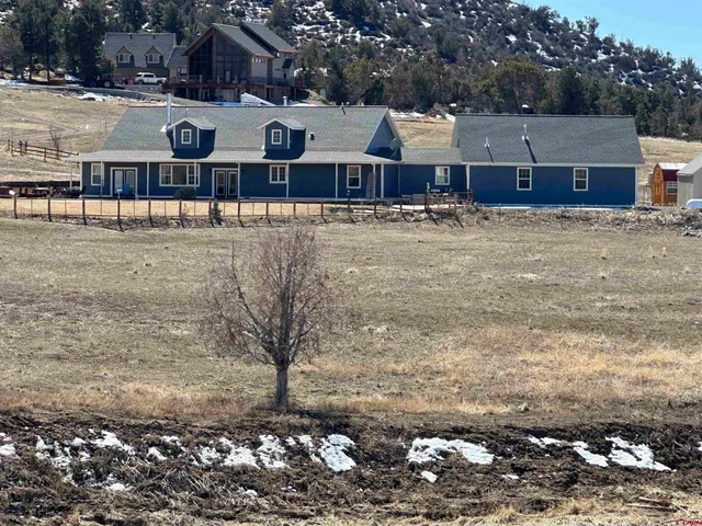a front view of residential houses with yard and trees