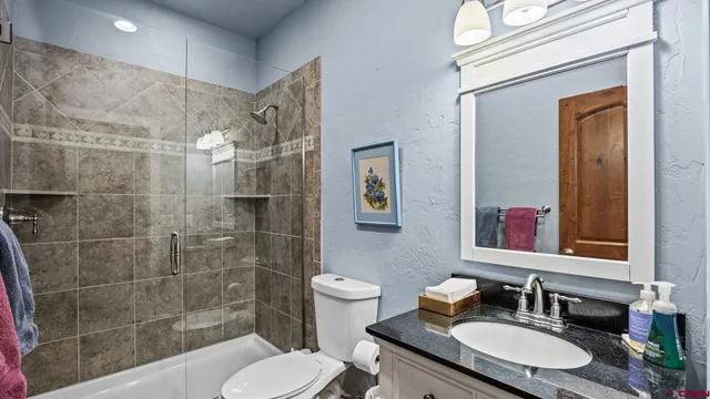 a view of a hallway with bathroom and wooden floor