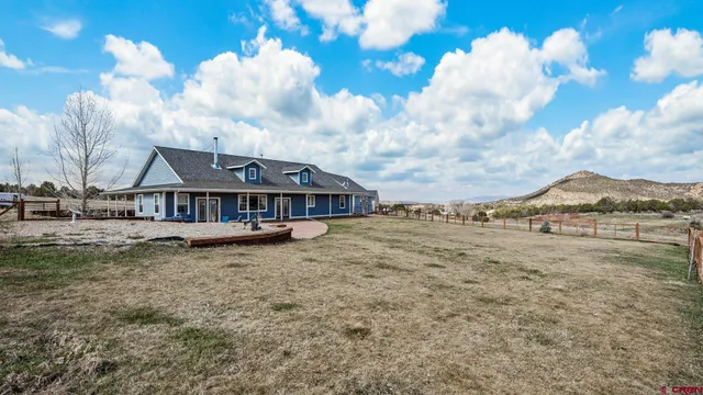 a view of a house with a big yard and large trees