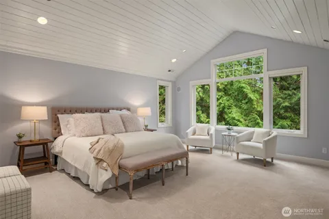 a spacious bedroom with a bed and large windows