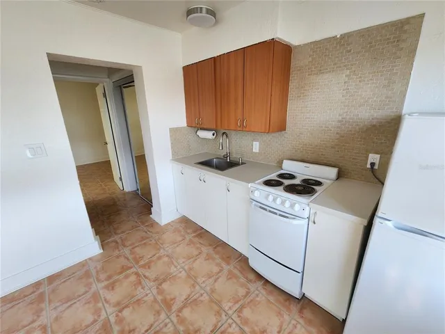 a kitchen with a sink a stove a refrigerator and cabinets