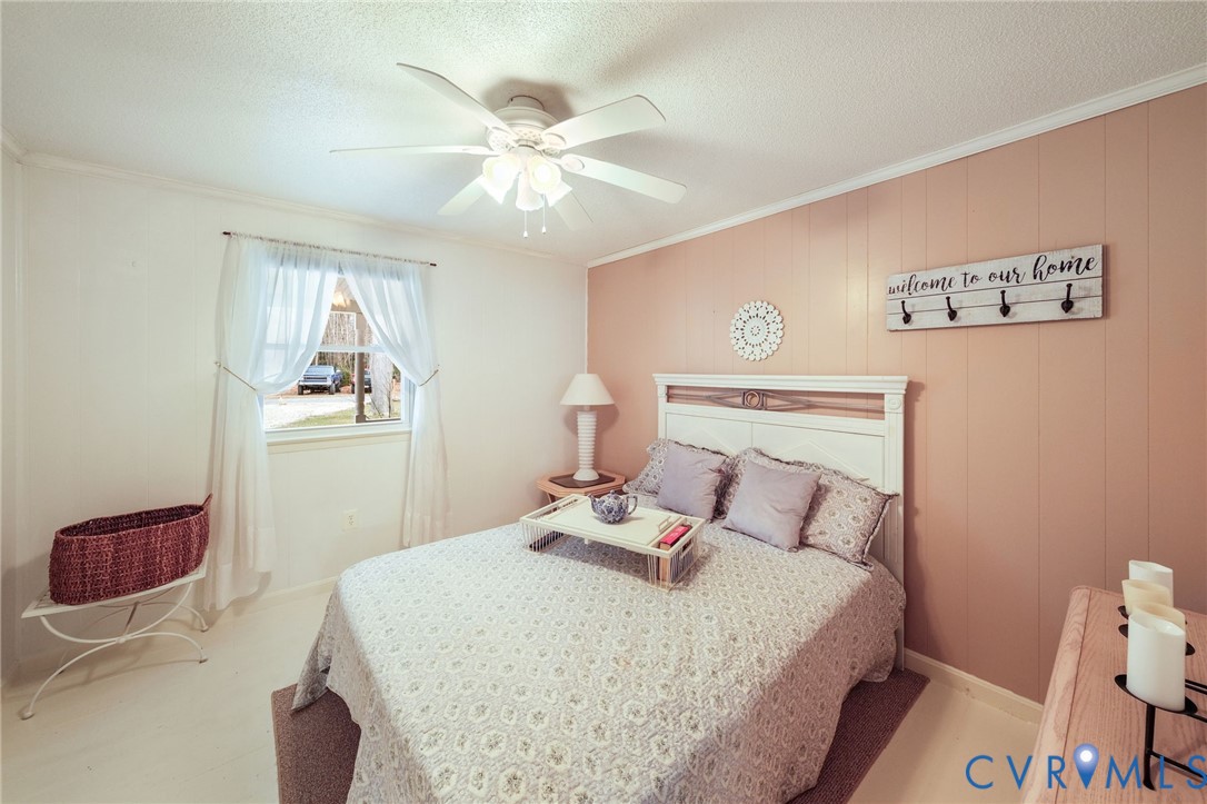 844 Monarch Shores Road Kilmarnock, VA 22482 - Photo 14 of 54 a bedroom with a bed and a chandelier