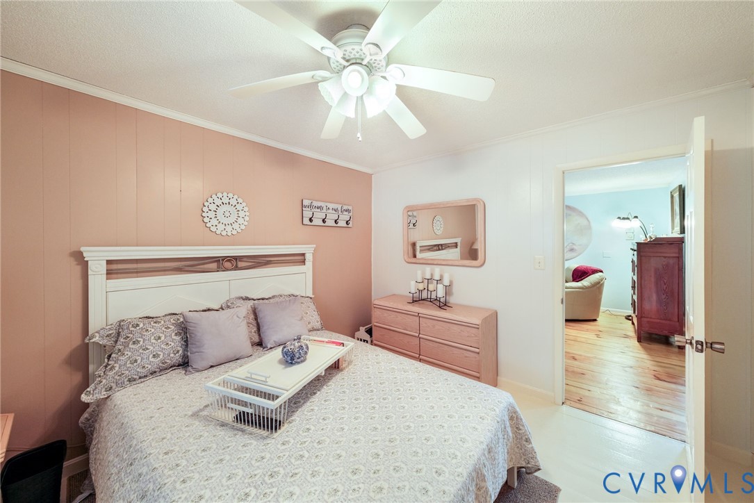 844 Monarch Shores Road Kilmarnock, VA 22482 - Photo 15 of 54 a bedroom with a large bed and a chandelier