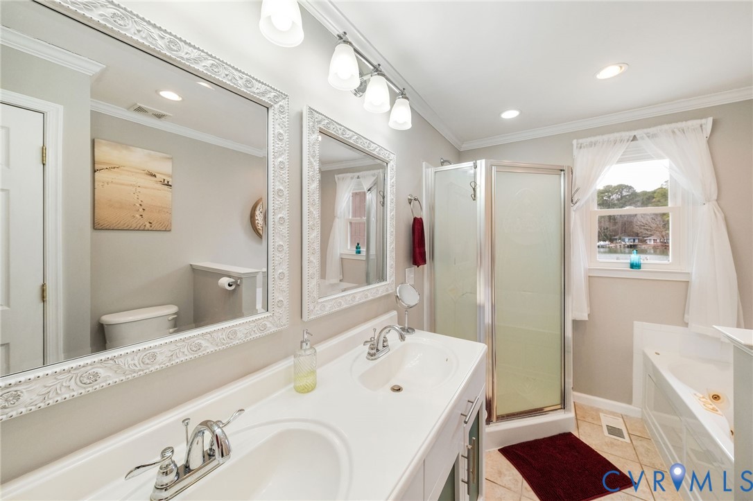 844 Monarch Shores Road Kilmarnock, VA 22482 - Photo 16 of 54 a spacious bathroom with a sink mirror vanity and toilet
