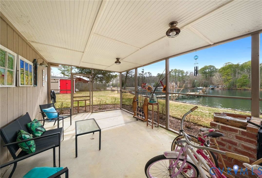 844 Monarch Shores Road Kilmarnock, VA 22482 - Photo 36 of 54 a living room with patio furniture and a floor to ceiling window