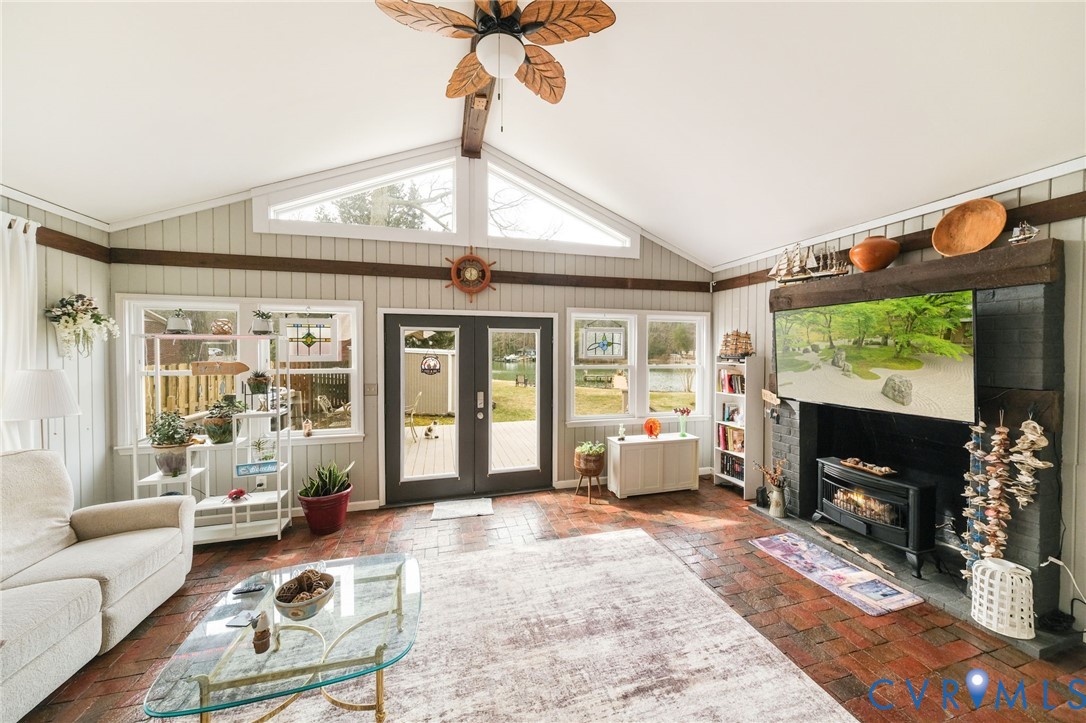 844 Monarch Shores Road Kilmarnock, VA 22482 - Photo 5 of 54 a living room with furniture a flat screen tv and a floor to ceiling window