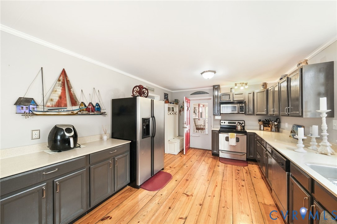 844 Monarch Shores Road Kilmarnock, VA 22482 - Photo 9 of 54 a kitchen with stainless steel appliances a sink a refrigerator and wooden floor