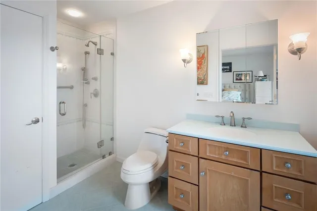 a bathroom with a granite countertop sink toilet a shower and a mirror