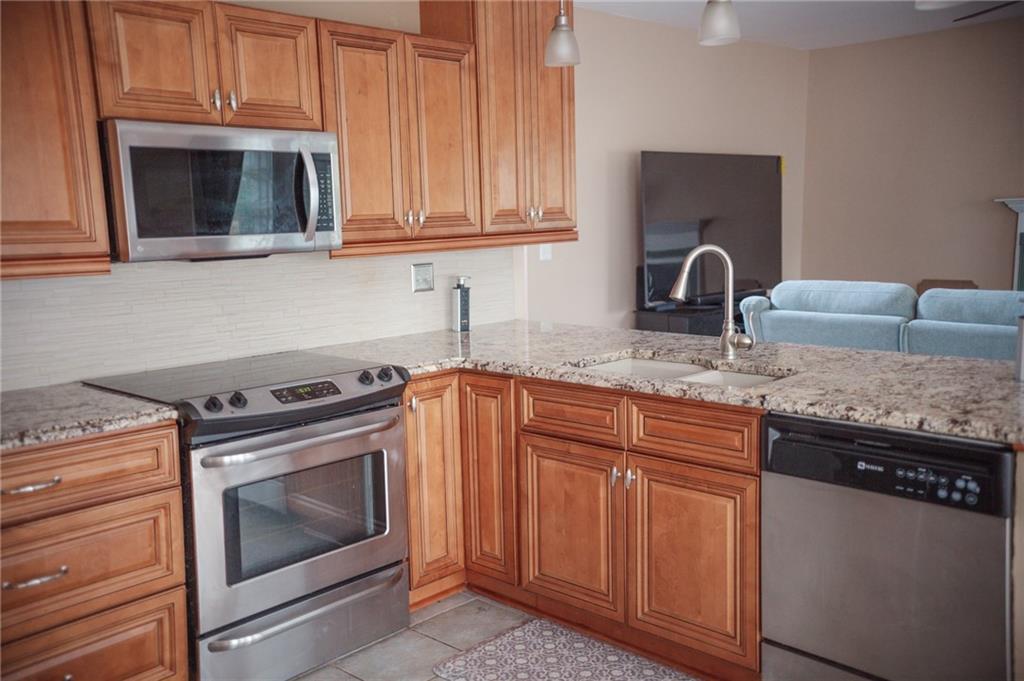 2932 Sunset View Circle Suwanee, GA 30024 - Photo 14 of 44 a kitchen with granite countertop a stove top oven microwave and cabinets