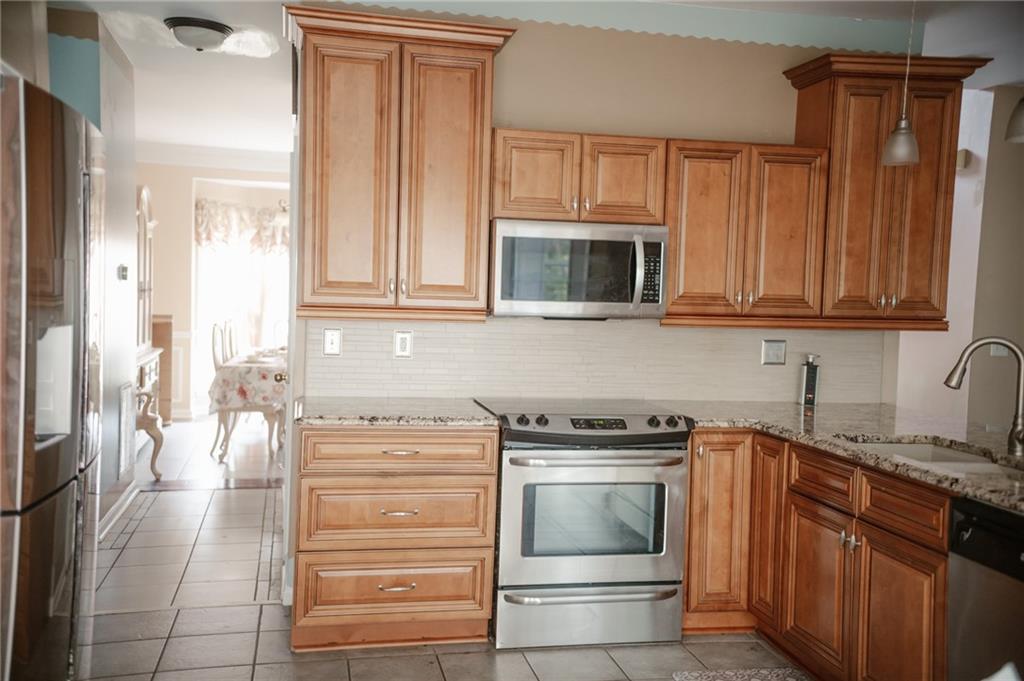 2932 Sunset View Circle Suwanee, GA 30024 - Photo 15 of 44 a kitchen with granite countertop a stove microwave and cabinets