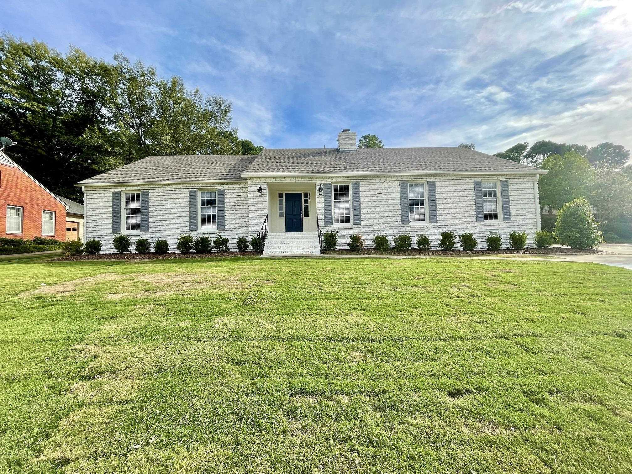 5523 Walnut Grove Road Memphis, TN 38120 - Photo 1 of 21 a front view of a house with a garden and trees