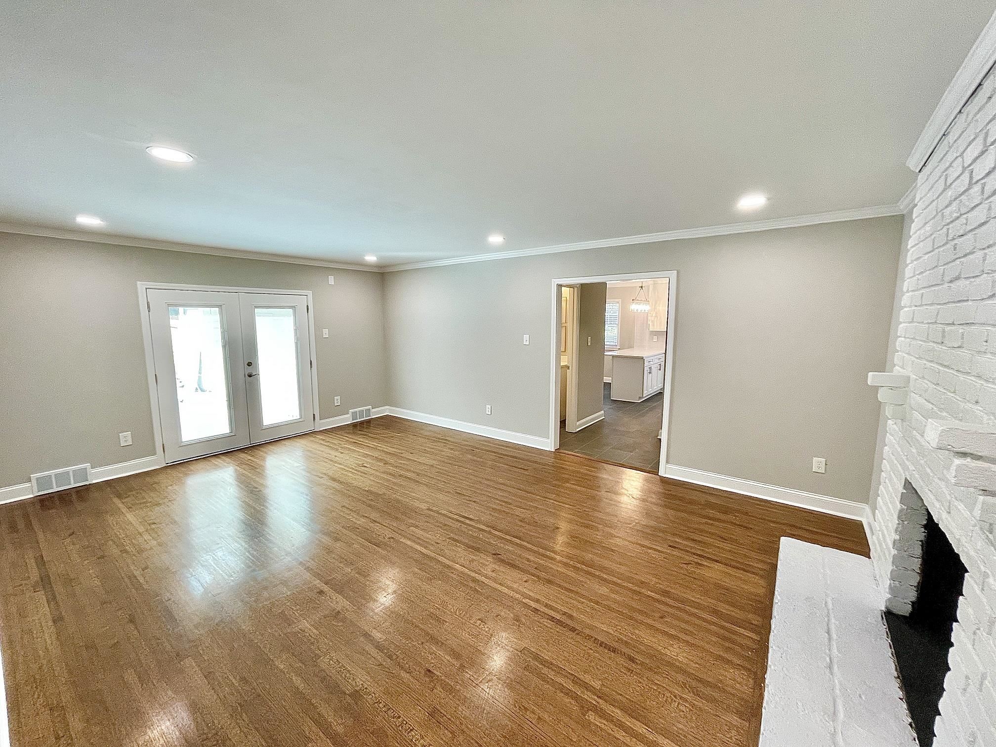 5523 Walnut Grove Road Memphis, TN 38120 - Photo 6 of 21 a view of an empty room with wooden floor and a fireplace