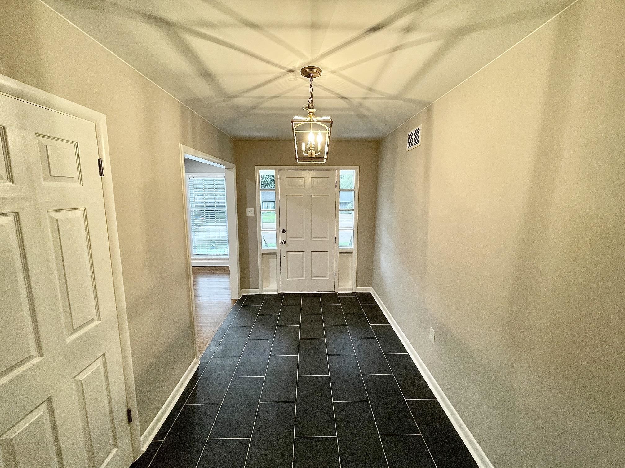 5523 Walnut Grove Road Memphis, TN 38120 - Photo 8 of 21 a view of a hallway with wooden floor and staircase