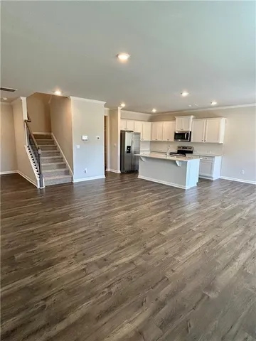 a view of kitchen with kitchen island granite countertop a stove top oven a sink and a counter space