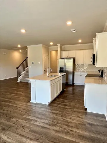 a large room with kitchen island a sink a stove and a refrigerator