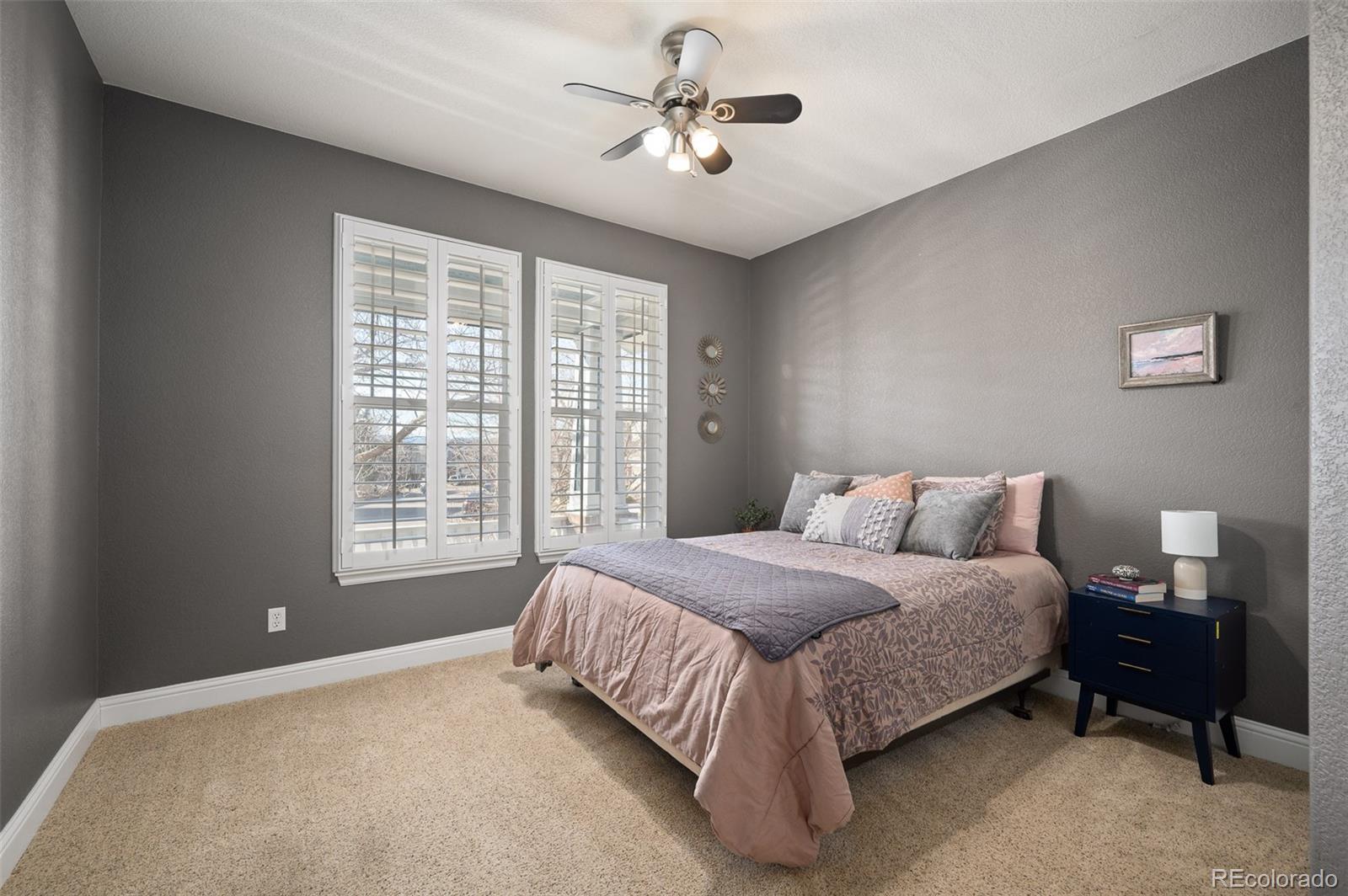 3559 Craftsbury Drive Highlands Ranch, CO 80126 - Photo 15 of 38 a spacious bedroom with a bed and a chandelier