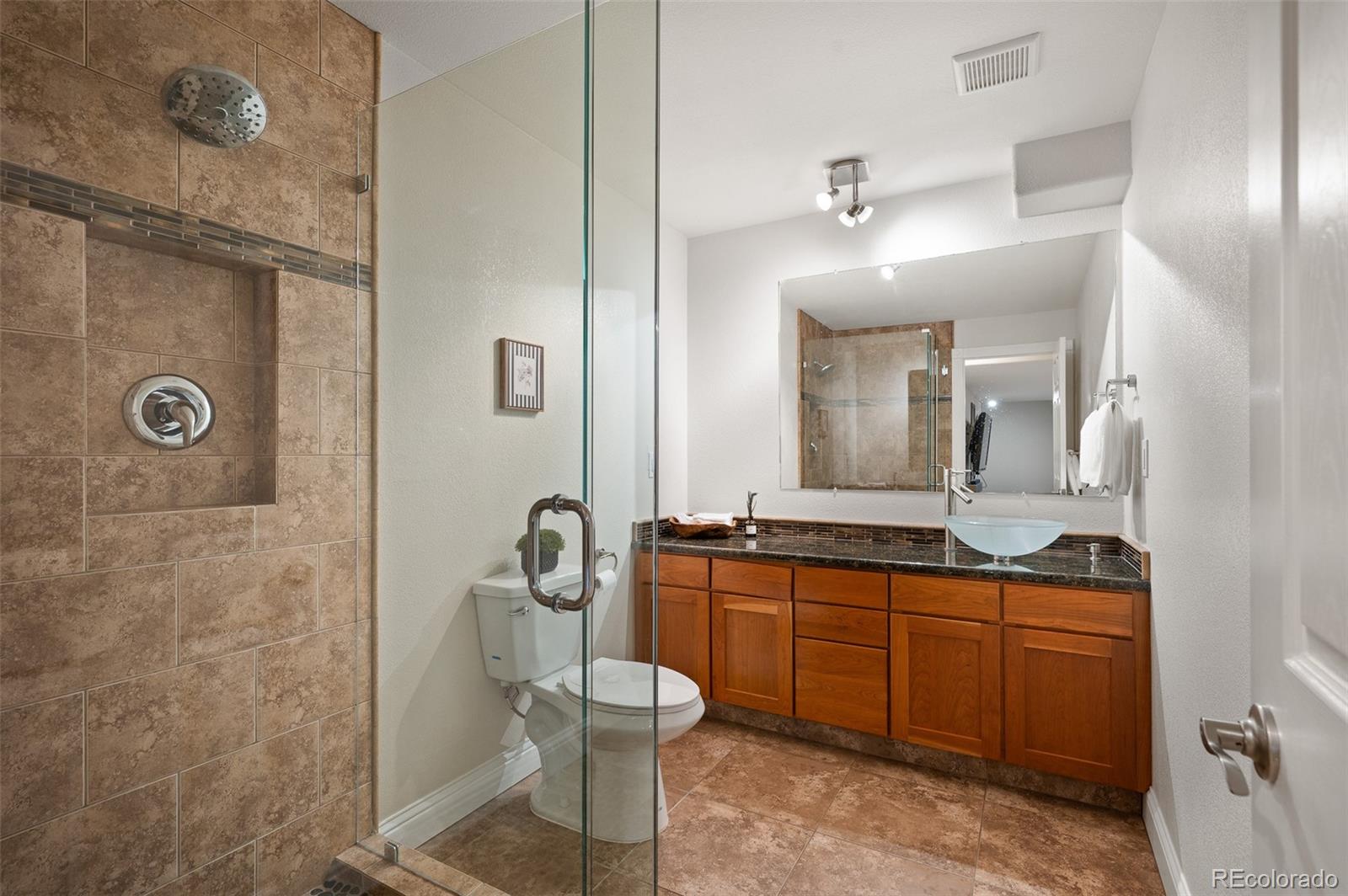 3559 Craftsbury Drive Highlands Ranch, CO 80126 - Photo 29 of 38 a bathroom with a double vanity sink a mirror and a shower