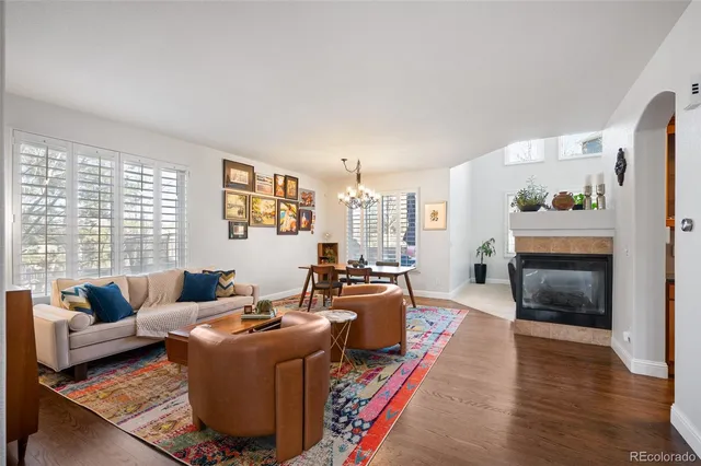 a living room with furniture kitchen view and a chandelier