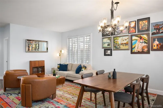 a kitchen with stainless steel appliances granite countertop a stove a refrigerator a sink a dining table and chairs with wooden floor