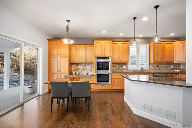 a large kitchen with kitchen island granite countertop a large window and stainless steel appliances