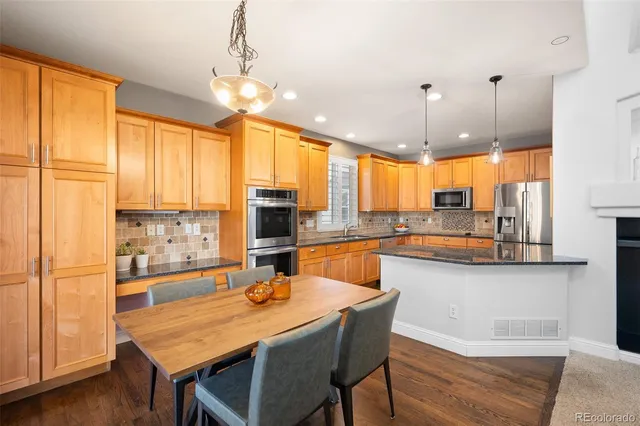 a bathroom with a granite countertop sink a toilet a mirror and shower