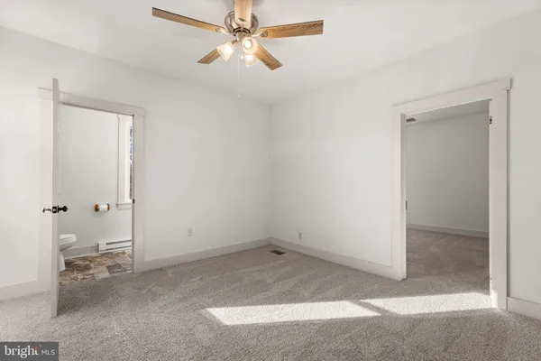 an empty room with closet and a chandelier fan