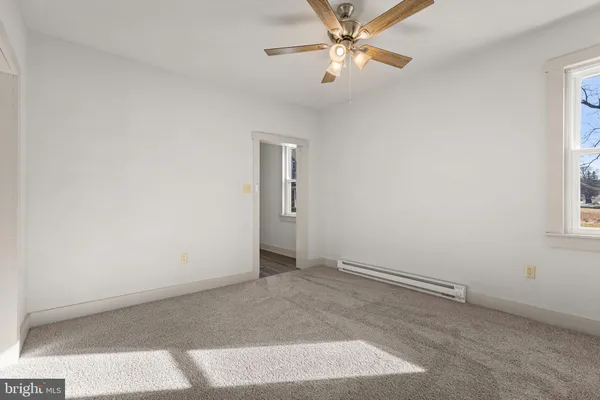 an empty room with windows and fan