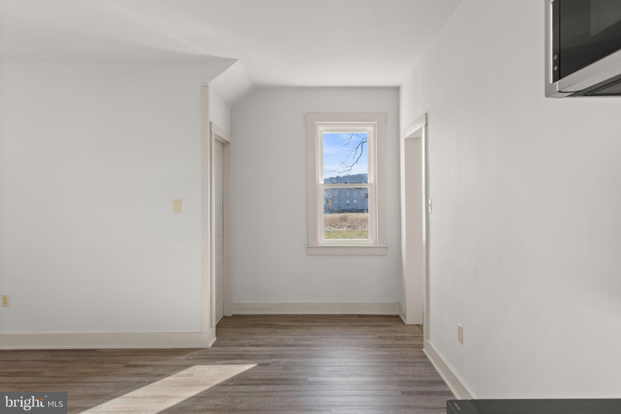 1586 Schwaben Creek Road Dornsife, PA 17823 - Photo 21 of 39 a view of an empty room with wooden floor and a window