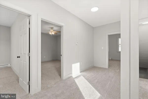 a view of an empty room with closet and a bathroom