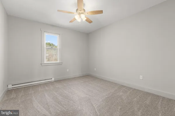 an empty room with a window and a fan