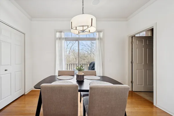 a dining room with wooden floor a chandelier