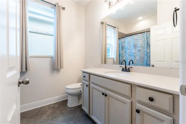 a bathroom with a granite countertop sink a toilet and a mirror