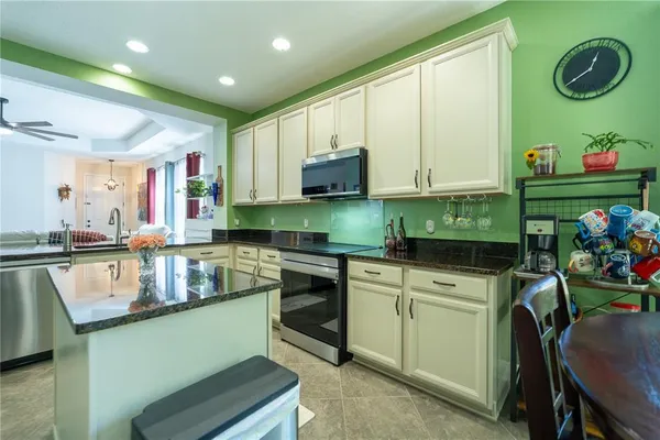 a kitchen with kitchen island granite countertop a sink cabinets and wooden floor