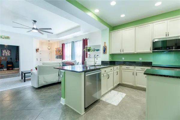 a kitchen with granite countertop a sink and white cabinets