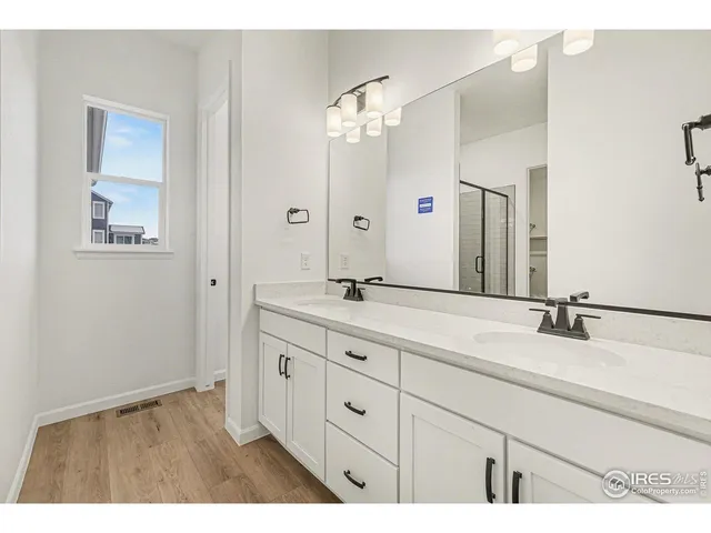 a bathroom with a double vanity sink and a mirror