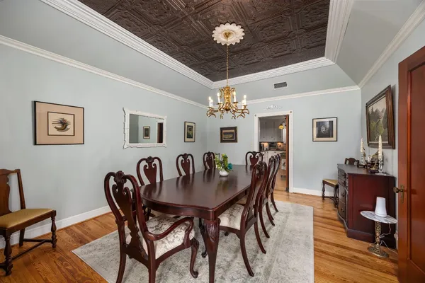 a view of a dining room with furniture a chandelier and wooden floor