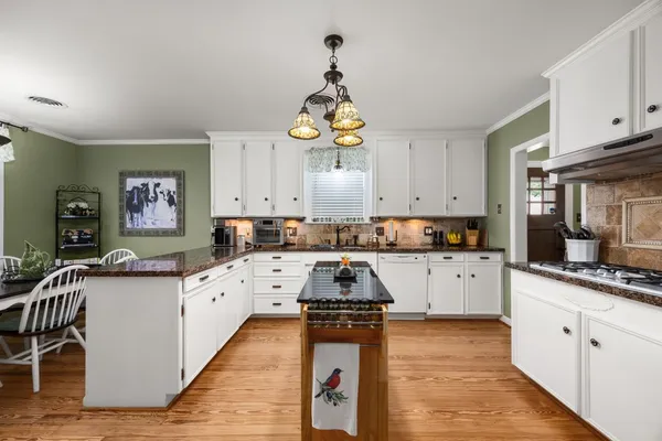 a kitchen with granite countertop a stove and cabinets