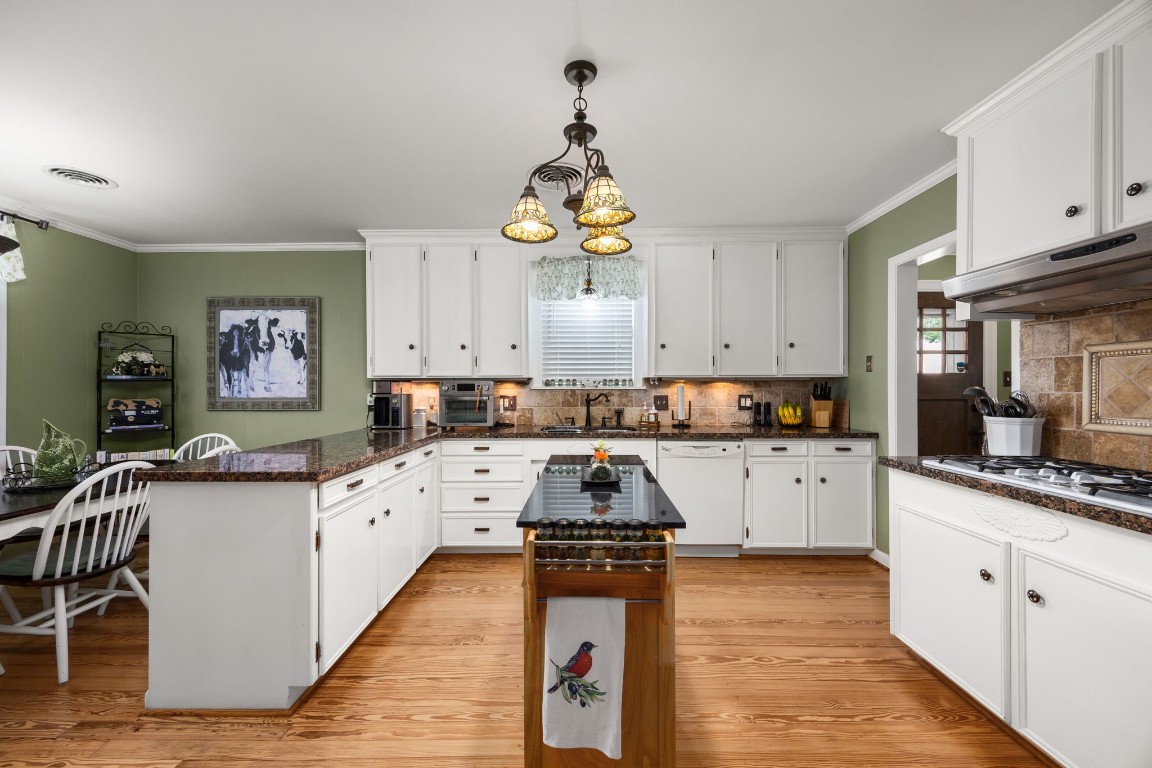 801 West Main Street Brenham, TX 77833 - Photo 15 of 50 Welcome to your spacious kitchen that offers abundant cabinet and countertop space, making it ideal for both everyday living and entertaining. Features include long board pine floors, white cabinetry, granite countertops, and so much more!