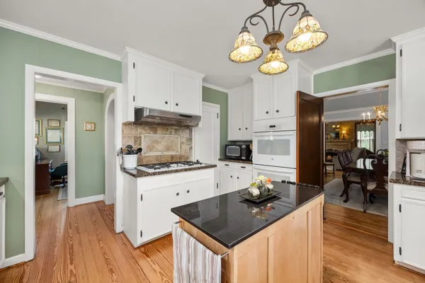 a kitchen with a stove cabinets and wooden floor