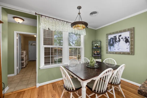 a view of a dining room with furniture wooden floor and a chandelier