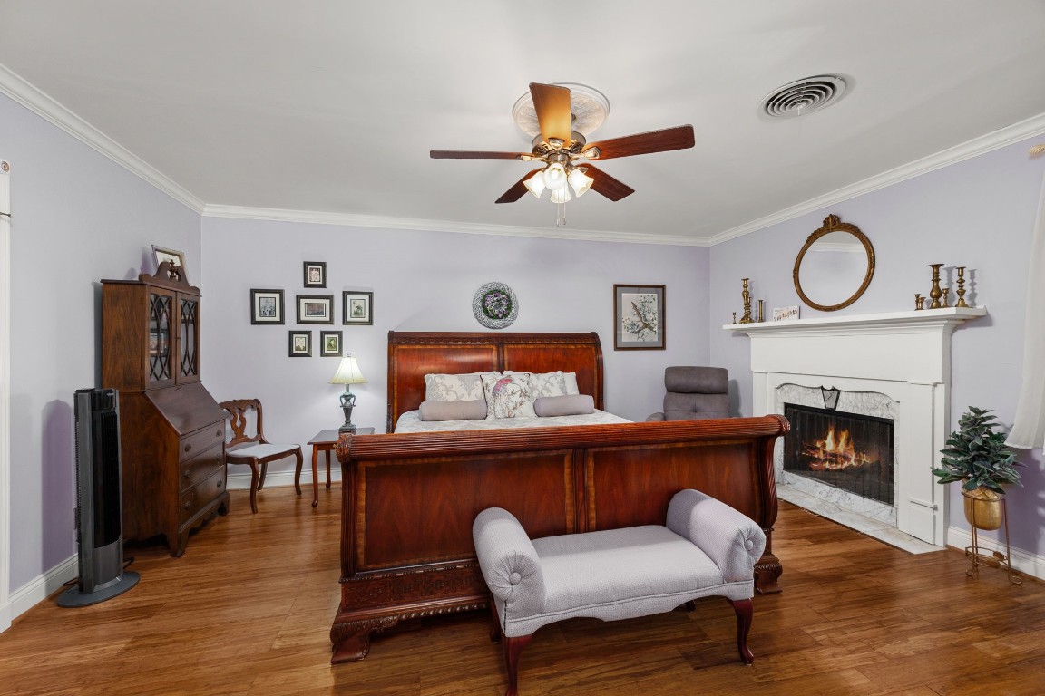 801 West Main Street Brenham, TX 77833 - Photo 21 of 50 One of two spacious primary suites, this downstairs retreat offers generous space, beautiful laminate floors, and a charming fireplace.