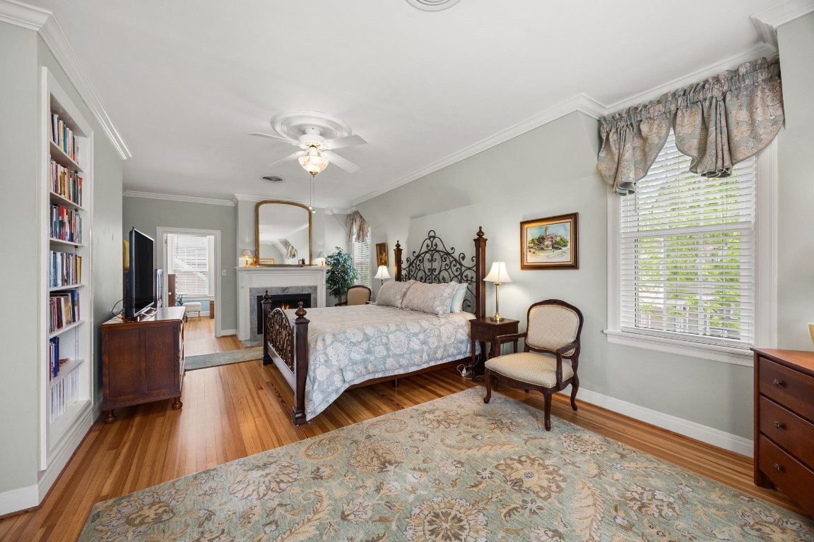 801 West Main Street Brenham, TX 77833 - Photo 25 of 50 The second primary suite upstairs is truly impressive, offering expansive proportions, long board pine floors, and abundant natural light. A cozy fireplace adds warmth and character.