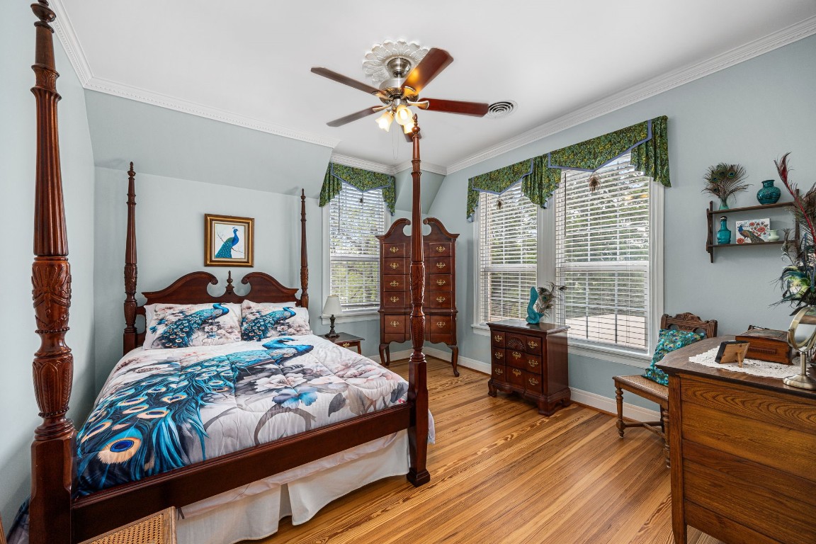 801 West Main Street Brenham, TX 77833 - Photo 31 of 50 This secondary bedroom offers long board pine floors, crown molding, and plenty of space for a full bedroom suite. Multiple windows bring in abundant natural light, while the ceiling fan adds comfort year round.