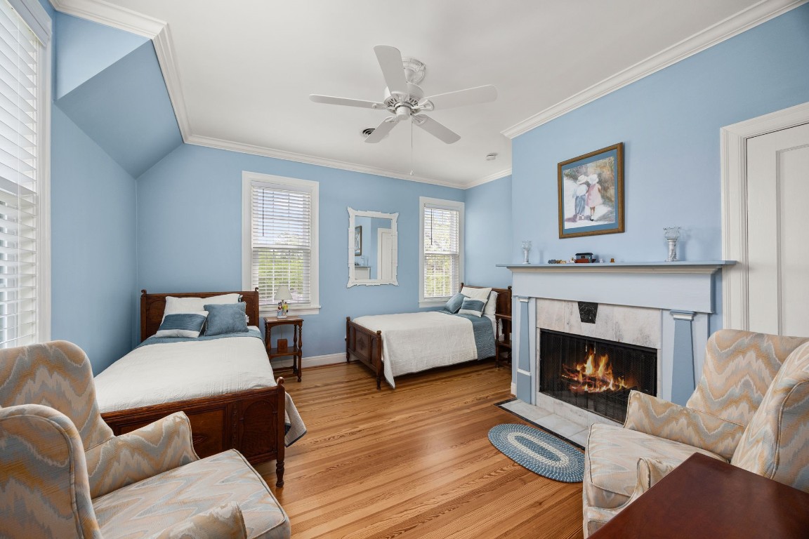 801 West Main Street Brenham, TX 77833 - Photo 33 of 50 This oversized secondary bedroom offers exceptional flexibility with enough room to comfortably accommodate multiple beds, a sitting area, or play space. Long board pine floors, crown molding, multiple windows, and a beautiful fireplace give the room warmth and character.