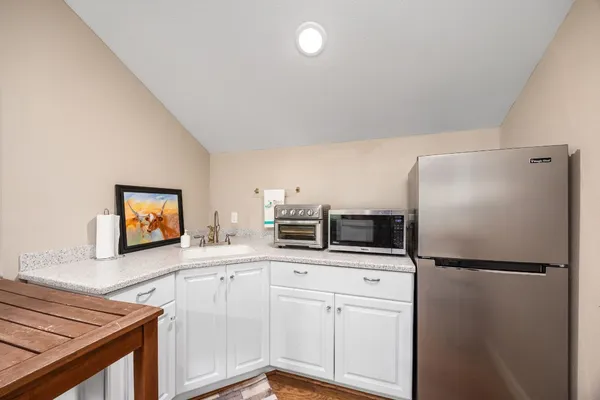 a kitchen with stainless steel appliances a refrigerator sink and microwave
