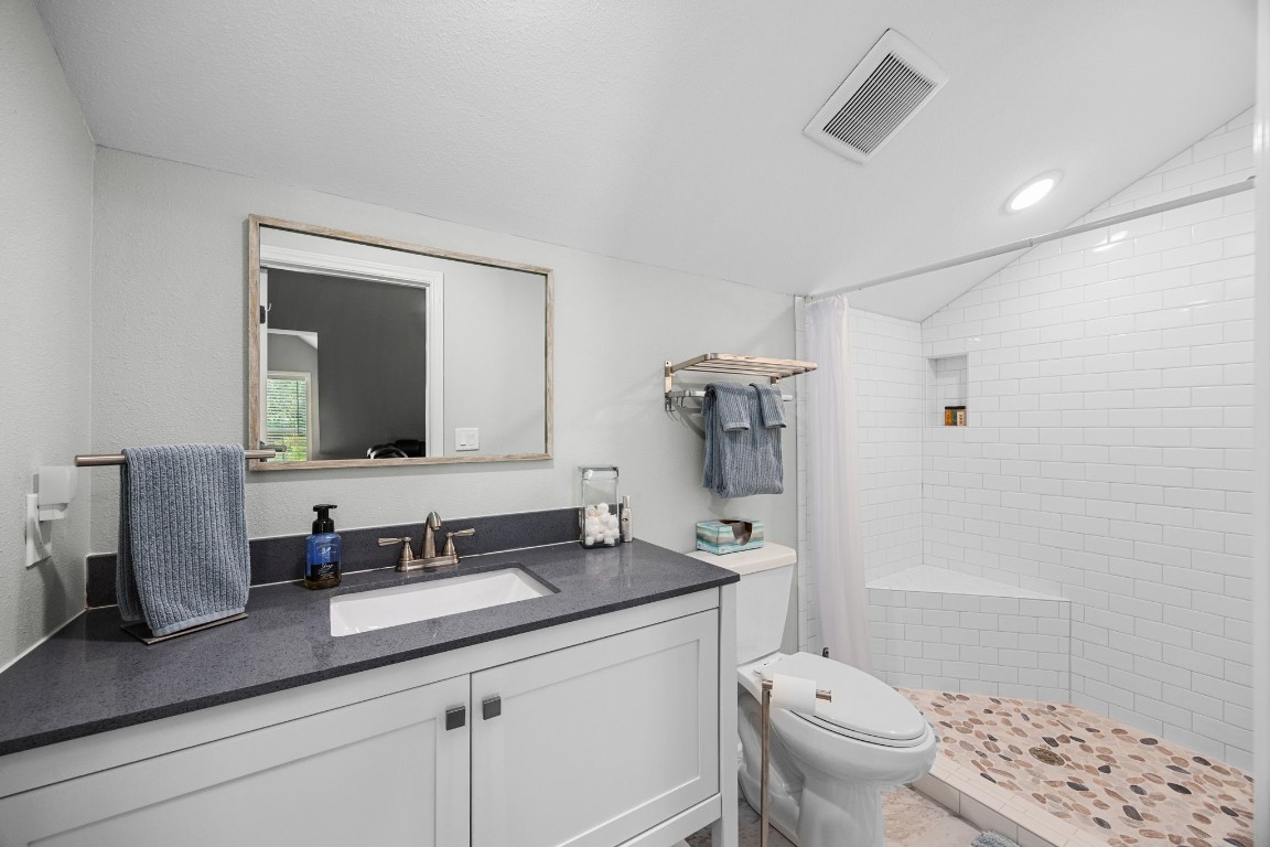 801 West Main Street Brenham, TX 77833 - Photo 39 of 50 The private bathroom above the garage has been beautifully updated with a vanity, sleek finishes, and an oversized walk in shower featuring subway tile, a pebble stone floor, and built in niche.