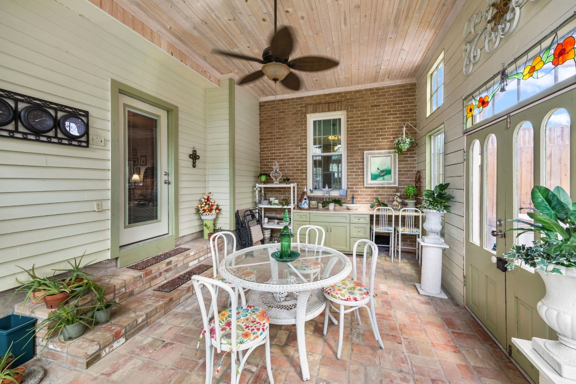 801 West Main Street Brenham, TX 77833 - Photo 41 of 50 French style double doors with decorative stained glass accents open to this impressive sunroom, where a striking brick accent wall and built in cabinetry create the perfect space for a sitting area, hobby room, entertaining space, or private retreat.